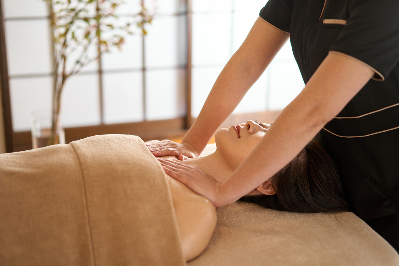 Woman receiving decollete massage at beauty salon